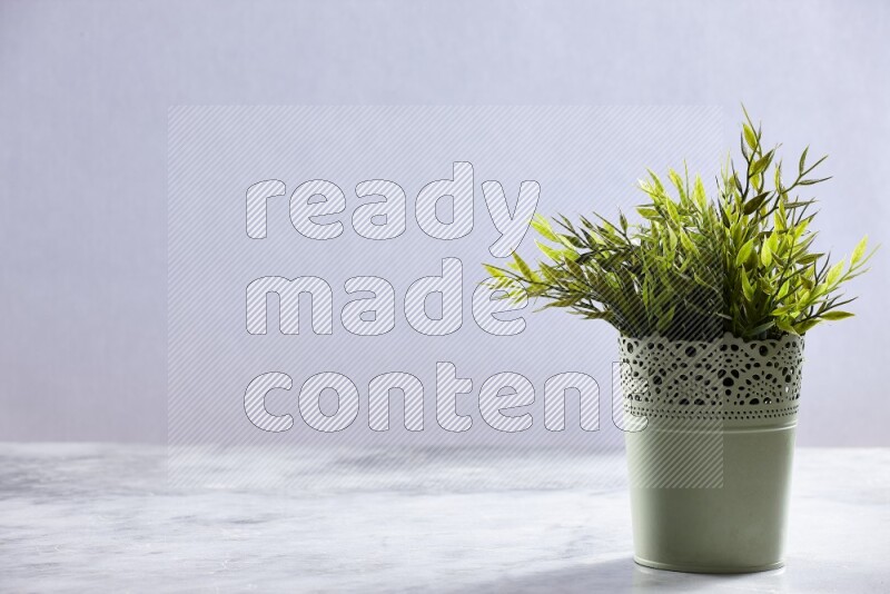 Artificial plant in green decorative pot on grey marble background
