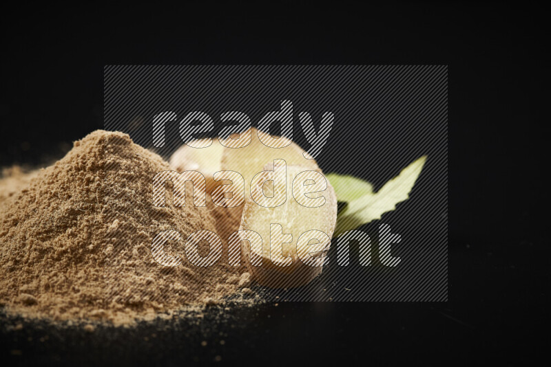 A bunch of ground ginger powder on black background