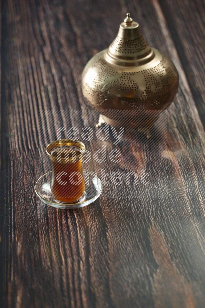 A golden lantern with different drinks, dates, nuts, prayer beads and quran on brown wooden background