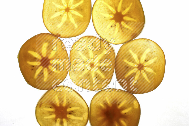 Persimmon slices on illuminated white background