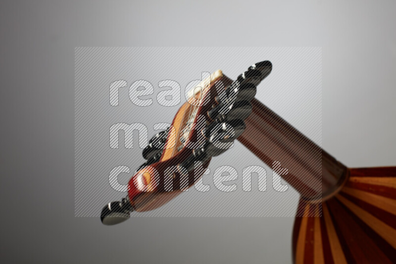 parts of a brown wooden Oud in a gray background