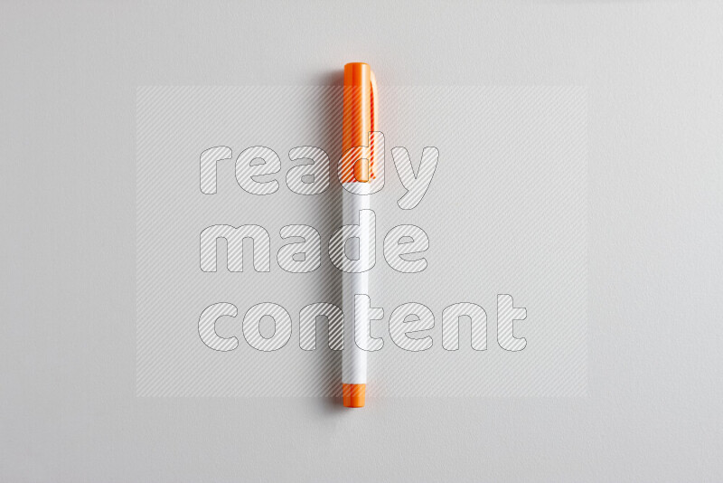 A close-up showing a single coloring pen with a cap on grey background