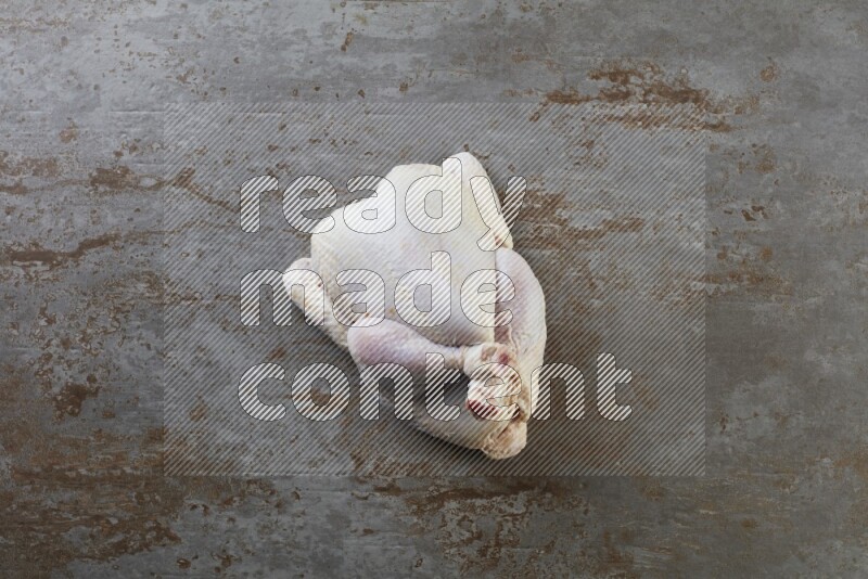 whole raw chicken  direct on a rustic grey background
