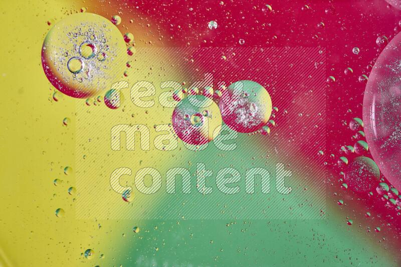 لقطات مقربة لفقاعات من الزيت على سطح الماء باللون الأصفر والأخضر والأحمر