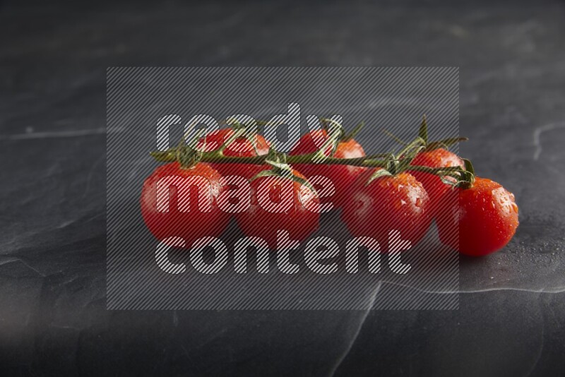 Red cherry tomato vein on a textured black slate background 45 degree