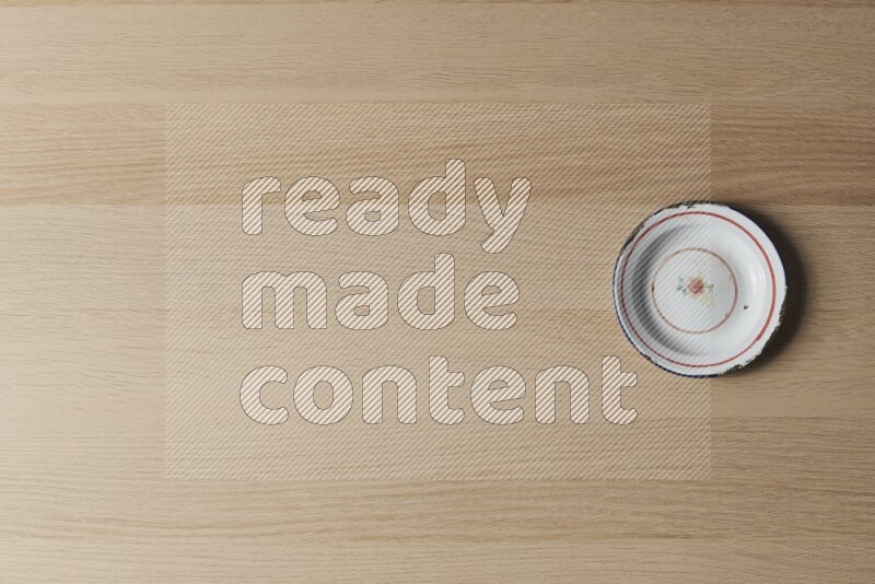 A vintage metal plate on light wooden background