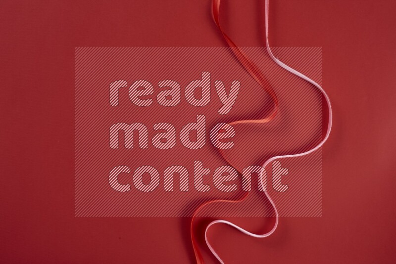 A pink and red collection of sewing and tailoring tools arranged on a red background