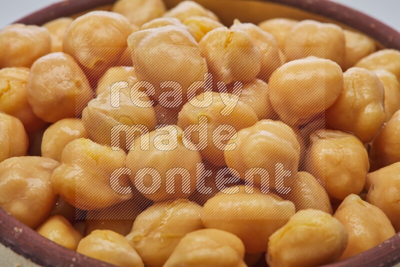 Close up shot of boiled chickpeas in a container on white background