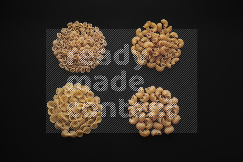 Different pasta types in bunches on black background