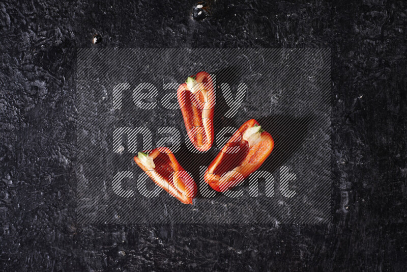Red bell pepper slices on black background