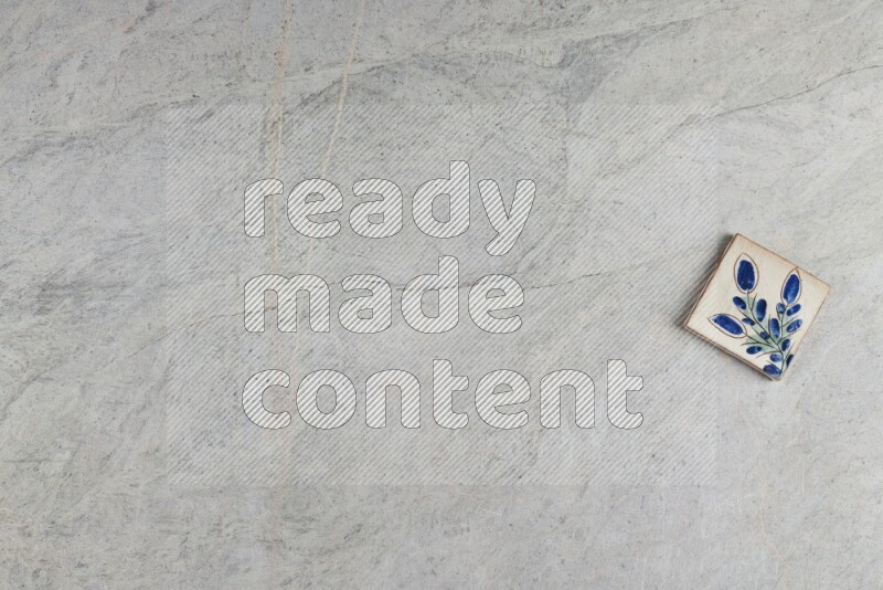 A decorative pottery coaster on grey marble background