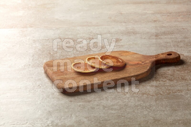 Three stacked plain mini pancakes on a wooden board on beige background