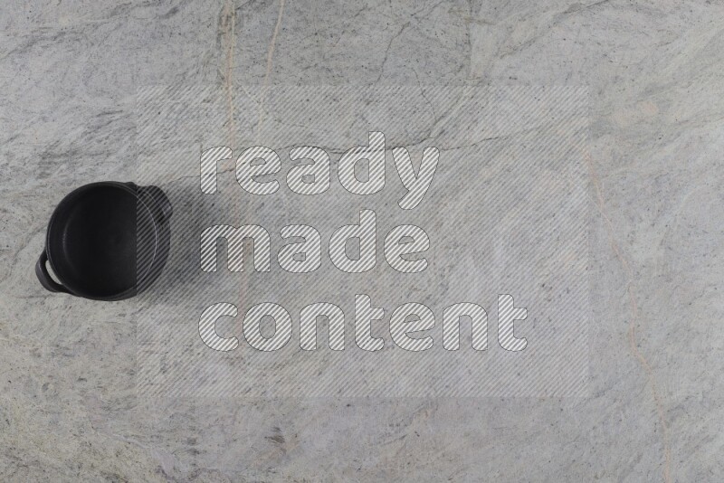A black pottery bowl on grey marble background