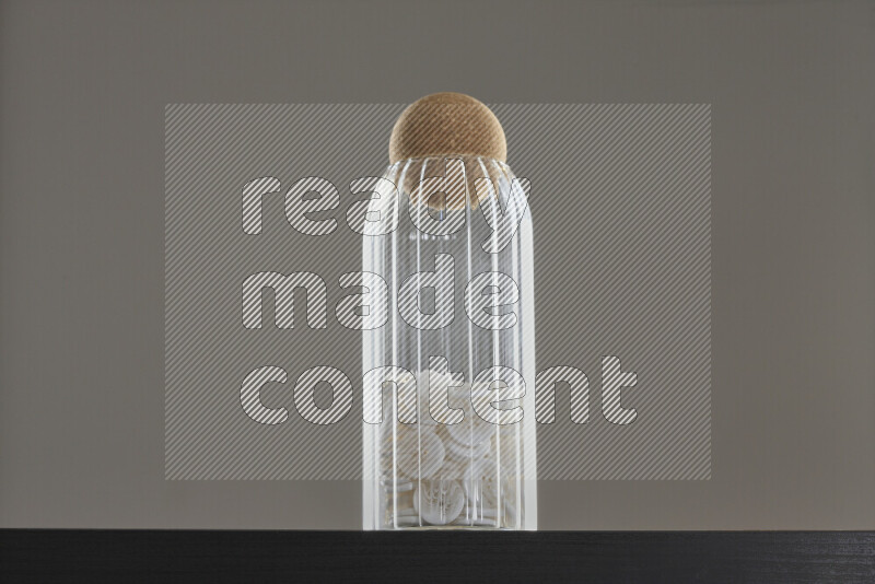 أزرار متنوعة في وعاء زجاجي علي خلفية سوداء