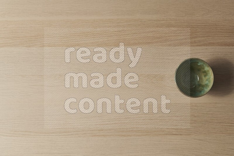 A dark green pottery bowl on light wooden background