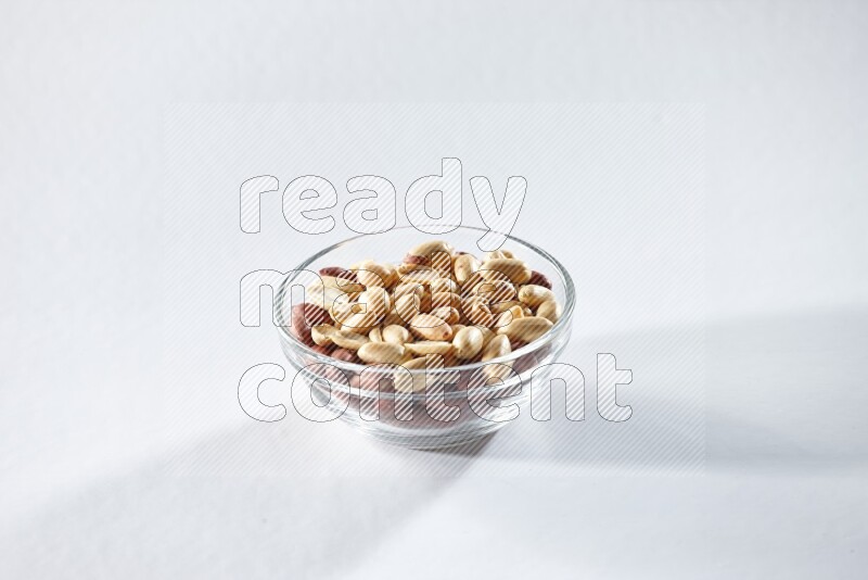 A glass bowl full of peeled peanuts on a white background in different angles