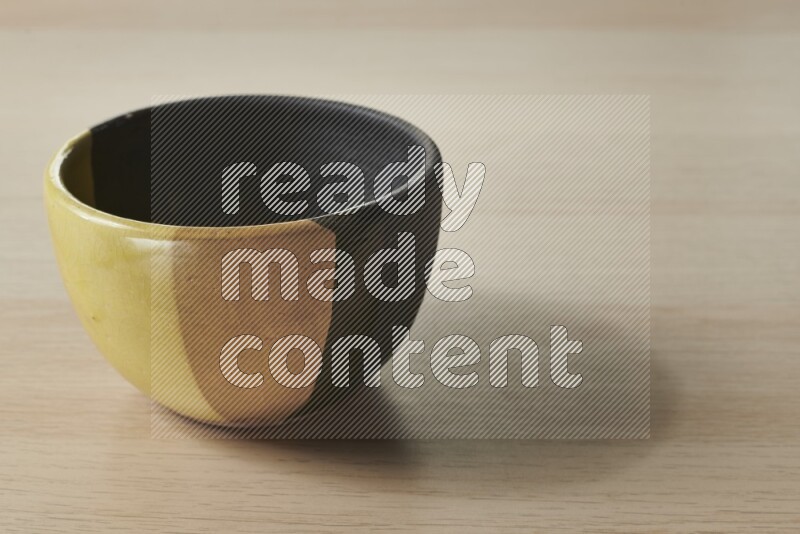 A multicolored pottery bowl on light wooden background