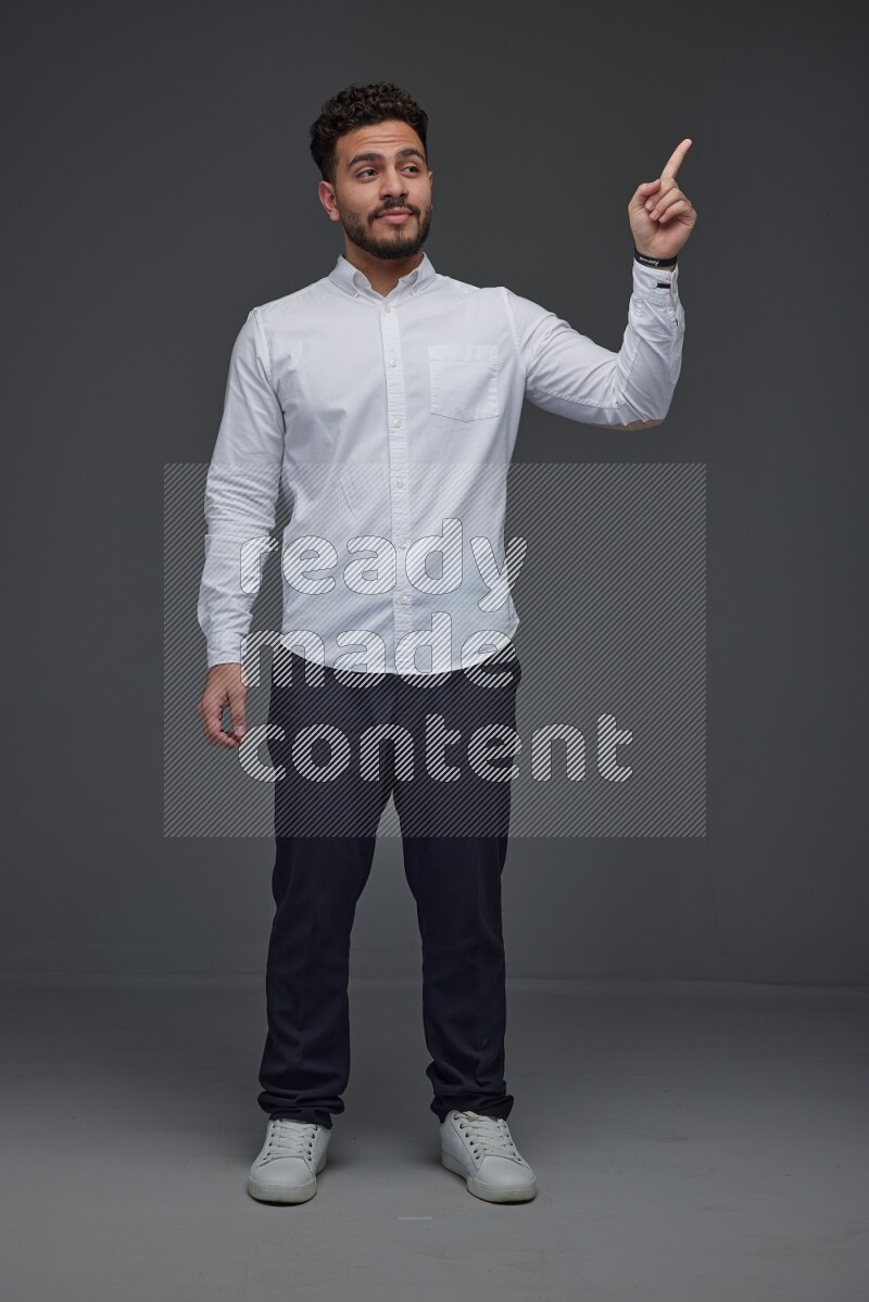 A man wearing smart casual standing and making multi hand gestures eye level on a gray background