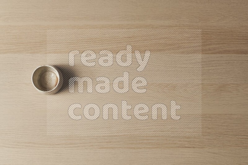 A pottery cup on light wooden background