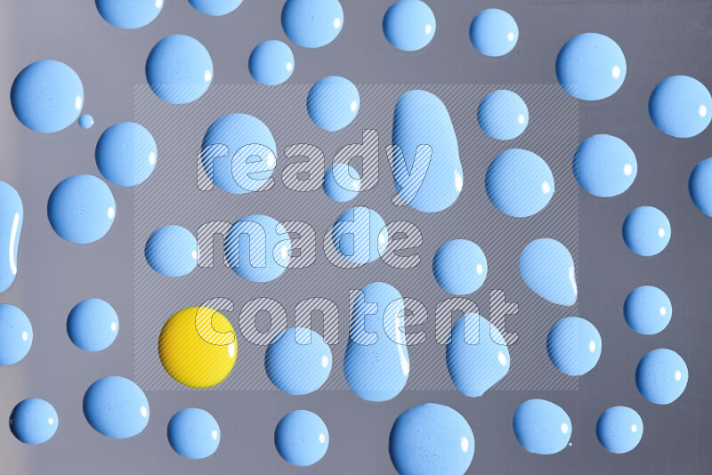 لقطات مقربة لقطرات من اللون الأزرق والأصفر على الخلفية