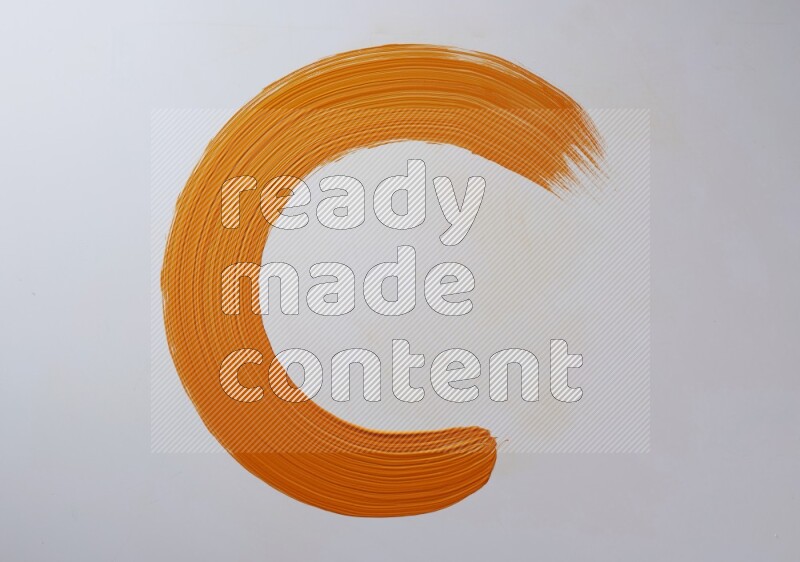 An orange circular painting brush stroke on white background