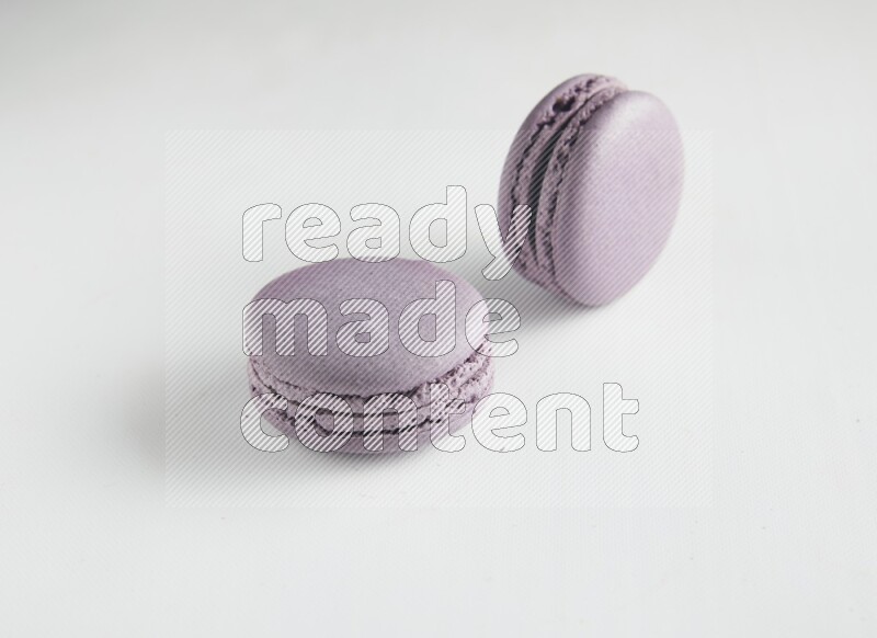 45º Shot of two Purple Blueberry macarons on white background