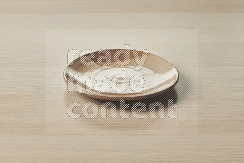 A multicolored pottery plate on light wooden background