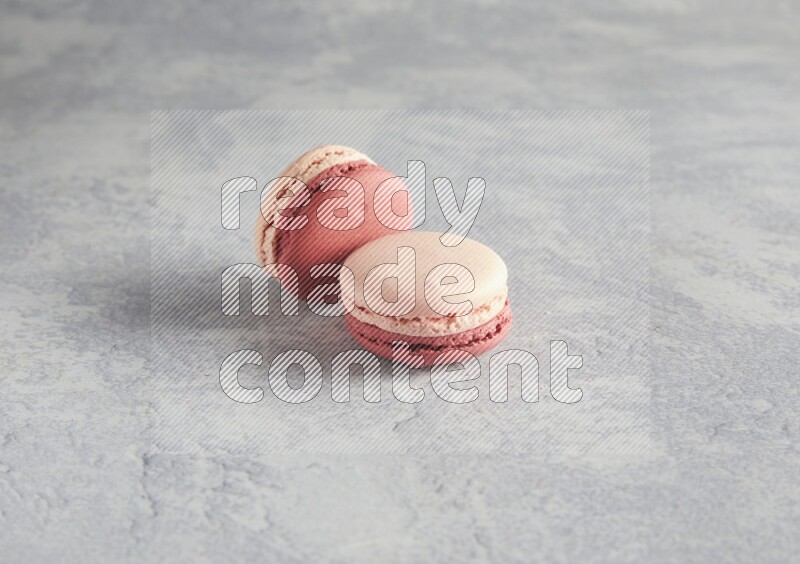 45º Shot of two Pink Litchi Raspberry macarons  on white  marble background