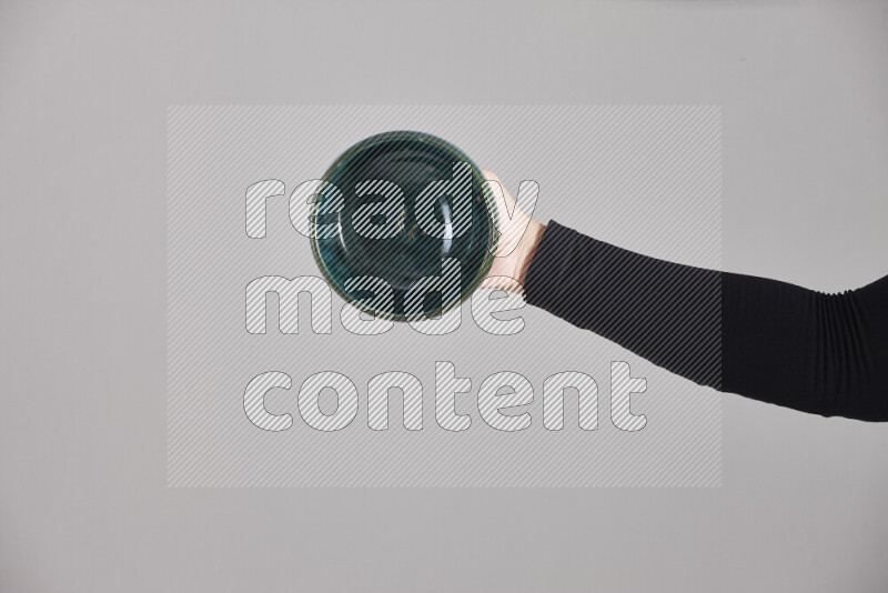 A woman in black abaya holding different pottery essentials in different positions