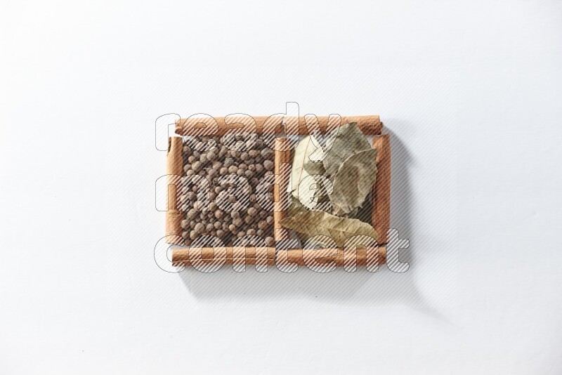 2 squares of cinnamon sticks full of allspice and bay laurel leaves on white flooring
