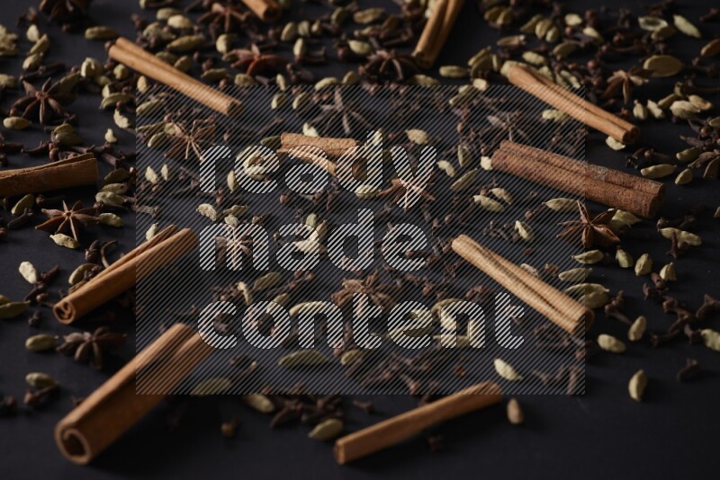 Cinnamon Sticks, Star anise, Cardamom and cloves on a black background