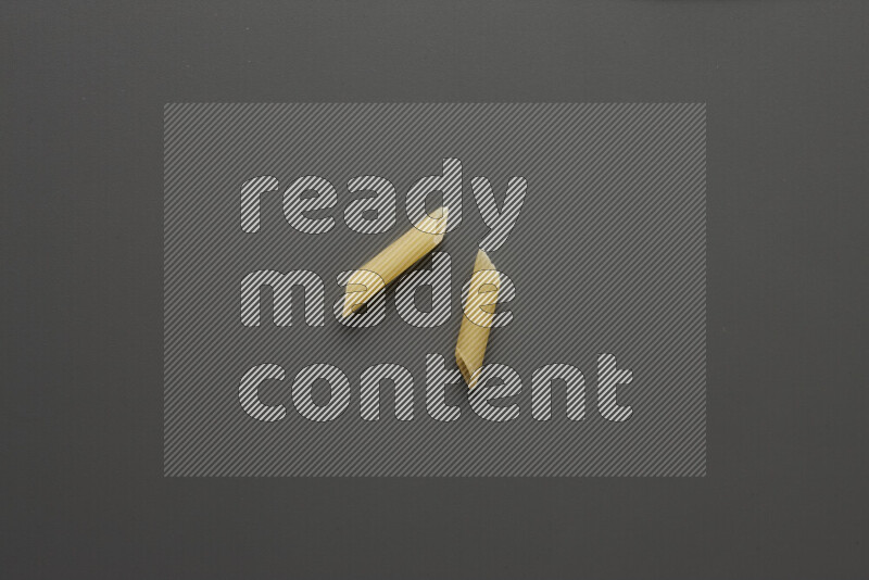Mini penne pasta on grey background