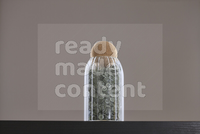 Buttons in a glass jar on black background