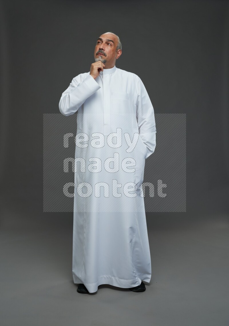 Saudi man without shomag Standing Interacting with the camera on gray background