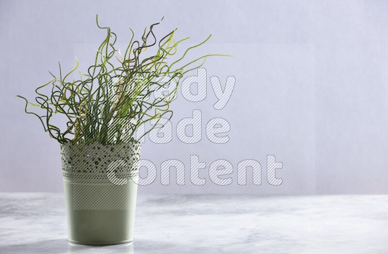 Artificial plant in green decorative pot on grey marble background