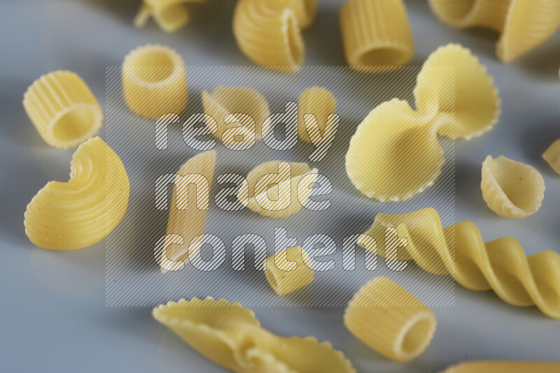 Different pasta types on light blue background