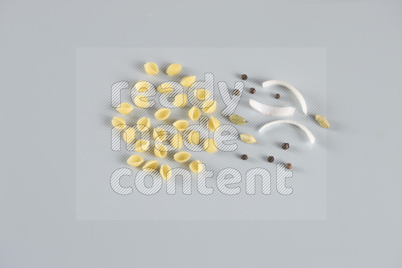 معكرونة مع مكونات متنوعة من الطماطم والثوم والبصل والفلفل الأحمر والفلفل الأسود والفلفل الأبيض وأوراق الغار وإكليل الجبل والهيل و مشروم على خلفية زرقاء فاتحة