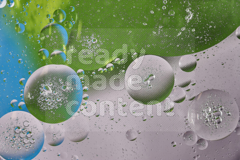 Close-ups of abstract oil bubbles on water surface in shades of white, green and blue