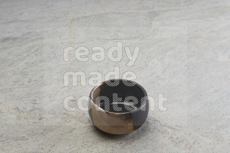 A multicolored pottery bowl on grey marble background