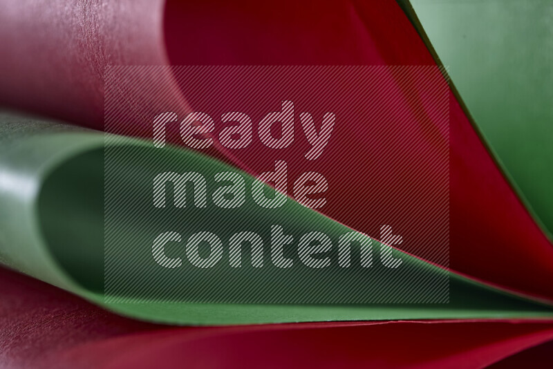 An abstract art showing red and green paper sheets arranged in an overlapping curves
