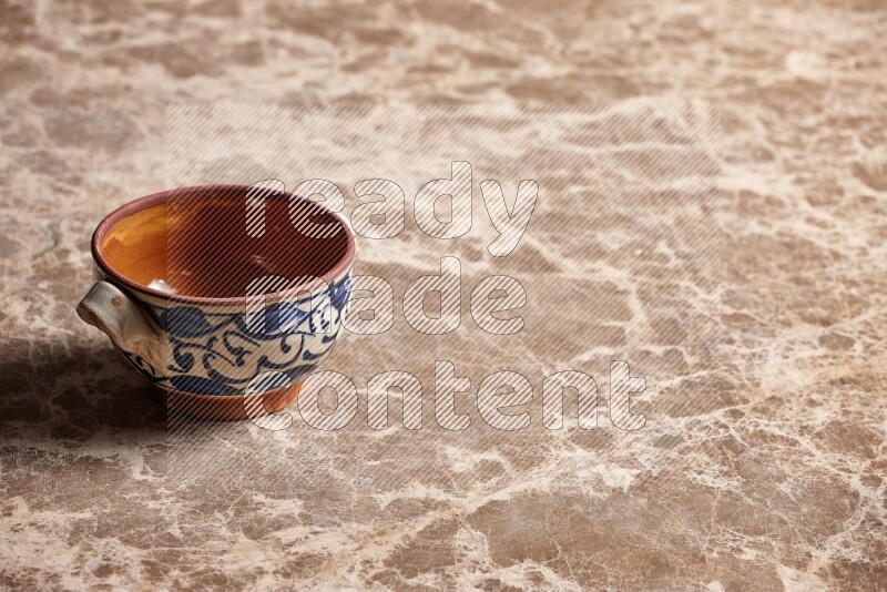 A decorative pottery bowl on beige marble background