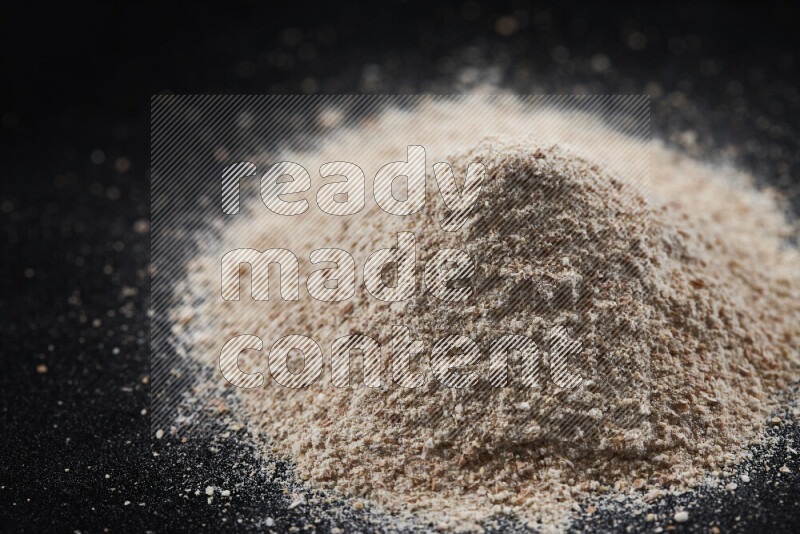 A bunch of onion powder on black background