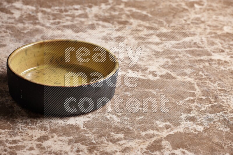 A multicolored pottery oven plate on beige marble background
