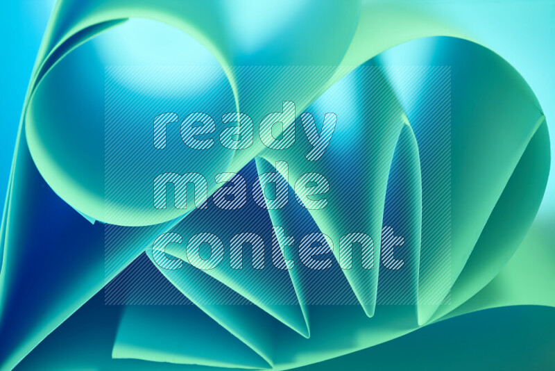 An artistic display of paper folds creating a harmonious blend of geometric shapes, highlighted by soft lighting in green and blue tones