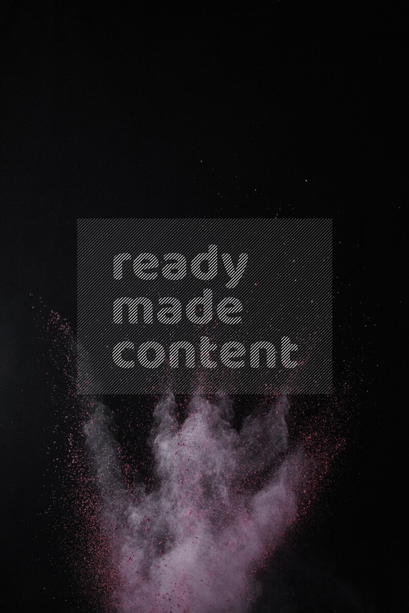 A side view of red powder explosion on black background