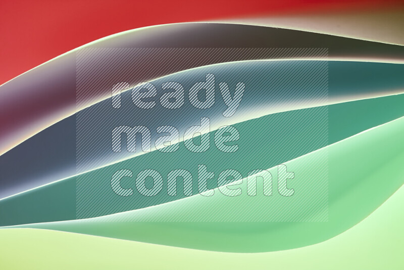 This image showcases an abstract paper art composition with paper curves in green and red gradients created by colored light