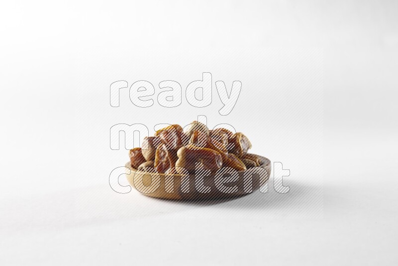 Dates in a wooden bowl on white background