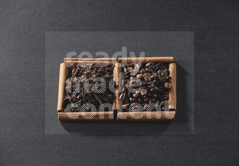 2 squares of cinnamon sticks full of coffee beans and cloves on black flooring