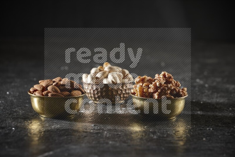 مكسرات في وعاء معدني علي خلفية سوداء