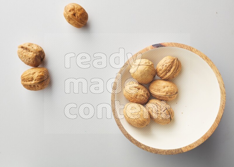 Top-view shot of walnut in a container on white background